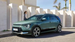 Moderner grüner SUV auf sonniger Straße vor weißer Wand