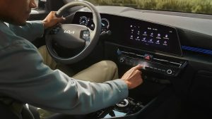 Mann bedient Armaturenbrett im modernen Auto-Innenraum
