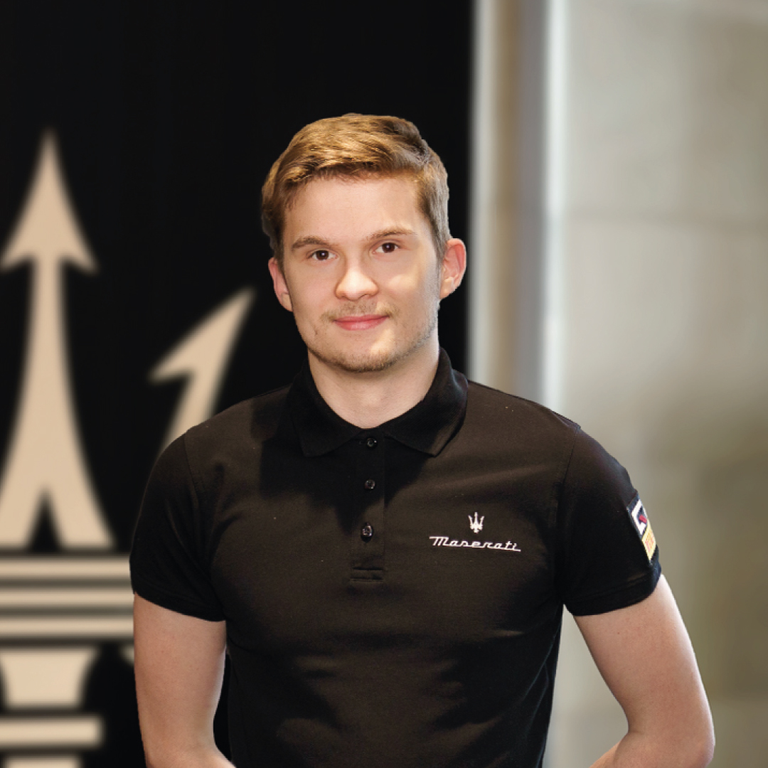 Junger Mann in Maserati-Polohemd vor Logo-Hintergrund
