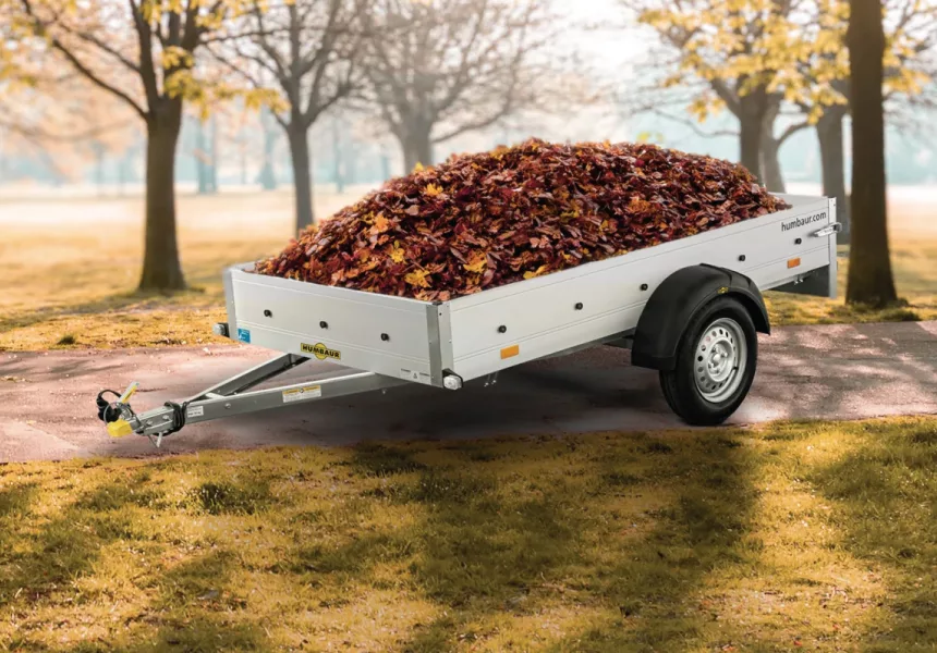 Anhänger voller Herbstlaub in einem sonnigen Parkumfeld